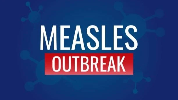 Graphic reading Measles Outbreak against a blue background.